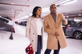 Elegant married couple in an underground parking lot opens car using alarm key fob Royalty Free Stock Photo