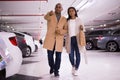 Elegant married couple in an underground parking lot opens car using alarm key fob Royalty Free Stock Photo