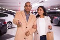 Elegant married couple in an underground parking lot opens car using alarm key fob Royalty Free Stock Photo