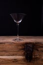 Elegant martini glass on wooden table with black wall background