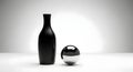 Elegant matte black bottle and shiny chrome sphere in a minimalist studio setup Royalty Free Stock Photo