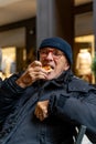 elegant mature man having a snack sitting in an outdoor cafe Royalty Free Stock Photo