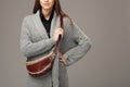 Elegant model in gray woven cardigan with a leather fanny pack Royalty Free Stock Photo