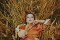 An elegant model lies on a wheat field enjoys nature. The concept of natural products, unity with nature, fashion. Beautiful young Royalty Free Stock Photo