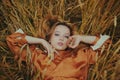 An elegant model lies on a wheat field enjoys nature. The concept of natural products, unity with nature, fashion. Beautiful young Royalty Free Stock Photo