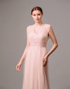 Elegant moscato dress with bow. Beautiful pink chiffon evening gown. Studio portrait of young brunette woman. Transformer dress id Royalty Free Stock Photo