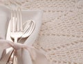 Elegant off white table place setting with silverware of fork, spoon and knife on cream cloth napkin and table cloth with room or Royalty Free Stock Photo