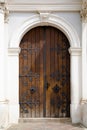 Elegant old double door entrance of building in Europe. Vintage wooden doorway and stucco fretwork wall of ancient stone Royalty Free Stock Photo