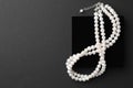 Elegant pearl necklace on black background, top view. Space for text Royalty Free Stock Photo