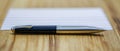 Elegant pen resting on a notepad on a wooden table Royalty Free Stock Photo