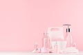 Elegant pink skin and body care products - cream, rose oil, liquid soap, salt, cotton towel and box on white wood table. Royalty Free Stock Photo