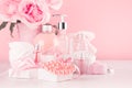 Elegant pink skin and body care products - cream, rose oil, liquid soap, salt, cotton towel - cosmetic accessories, flower.