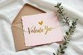 Elegant pink valentine's card with gold script and heart design on textured fabric Royalty Free Stock Photo