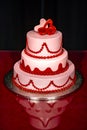 Elegant pink wedding cake decorated with red and pink roses and hearts Royalty Free Stock Photo