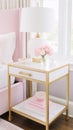 Elegant pink and white feminine bedroom interior with gold accents and fresh flowers in a crystal vase on a marble table Royalty Free Stock Photo