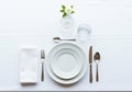 Elegant place setting on a white tablecloth. Features two stacked white plates with a Royalty Free Stock Photo