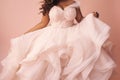 Elegant plus-sized African American bride in a flowing white wedding dress in peach background. Concept of bridal joy Royalty Free Stock Photo