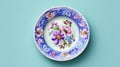 Elegant porcelain plate with floral ornament on blue background. Royalty Free Stock Photo
