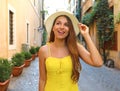 Elegant portrait of beautiful fashion woman with hat and long hair in yellow summer dress walking in Trastevere neighborhood Rome Royalty Free Stock Photo