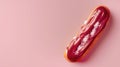 An elegant raspberry eclair with a vibrant glaze and sugar crystals on a soft pink surface Royalty Free Stock Photo