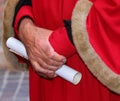 elegant red dress with soft fur inserts and the parchment in the man s hand