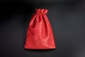 Elegant red fabric gift bag on black background with drawstring closure Royalty Free Stock Photo
