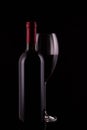 Elegant red wine glass and black wine bottle on black  background Royalty Free Stock Photo