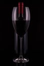 Elegant red wine glass and black wine bottle on black  background Royalty Free Stock Photo
