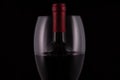 Elegant red wine glass and black wine bottle on black  background Royalty Free Stock Photo