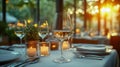 Elegant restaurant table setting with a wine glass at sunset, surrounded by candles and greenery Royalty Free Stock Photo