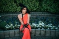 Elegant retro lady in a long red evening dress. Young stylish woman in a black hat with wide brim and high tulle gloves Royalty Free Stock Photo