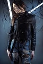 Elegant robot girl in wires in style cyberpunk in leather jacket and ripped jeans Royalty Free Stock Photo