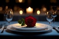 Elegant romantic dinner setting with a red rose on a plate, candlelight Royalty Free Stock Photo
