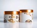 Elegant round gift boxes with golden floral patterns and shiny copper lids placed on smooth reflective white surface against soft Royalty Free Stock Photo