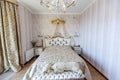 Elegant Royal white bedroom with a large double bed. White Carved back with a small canopy, white bedside tables with curved legs. Royalty Free Stock Photo