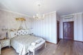 Elegant Royal white bedroom with a large double bed. White Carved back with a small canopy Royalty Free Stock Photo