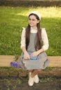 Elegant schoolgirl child girl with book in park, homework concept Royalty Free Stock Photo