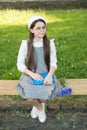 Elegant schoolgirl child girl with book in park, homework concept Royalty Free Stock Photo