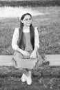 Elegant schoolgirl child girl with book in park, homework concept Royalty Free Stock Photo