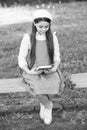 Elegant schoolgirl child girl with book in park, reading poetry concept Royalty Free Stock Photo