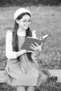 Elegant schoolgirl child girl reading book in park, french language concept Royalty Free Stock Photo