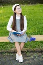 Elegant schoolgirl child girl reading book in park, learn grammar concept