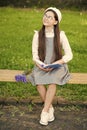 Elegant schoolgirl child girl reading book in park, learn grammar concept Royalty Free Stock Photo