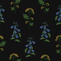 Elegant seamless pattern with embroidered blooming bellflower and tansy flowers on black background. Backdrop with