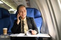 Elegant senior woman negotiating with business partners during business travel flight