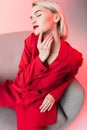 elegant sensual fashionable girl in red clothes posing in armchair