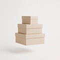 Floating Stack of Three Minimalist Beige Kraft Paper Square Gift Boxes on a White Background Royalty Free Stock Photo