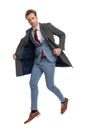 Elegant sexy man in blue suit jumping in the air and opening jacket Royalty Free Stock Photo