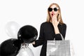 Elegant shocked girl, in black dress with sunglasses, with bags Royalty Free Stock Photo