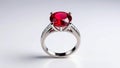 Elegant silver ring with a large red gemstone and smaller diamonds on a white background Royalty Free Stock Photo